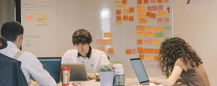 Small business team planning with laptops and sticky notes